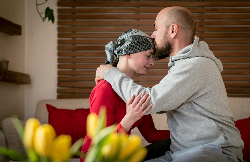 A man kisses a woman on the forehead.